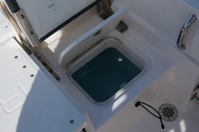 Slide: The Image of 2023 Robalo R230 Center Console livewell with open lid and water inside. - 11