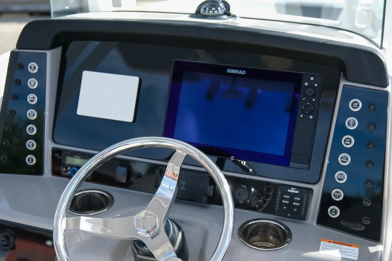 Slide: The Image of 2023 Robalo R230 Center Console dashboard with steering wheel and Simrad display. - 12