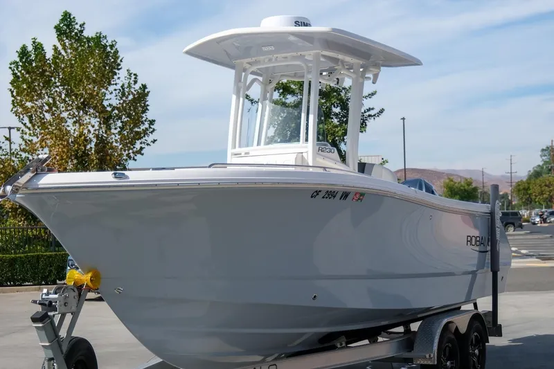 Slide: The Image of 2023 Robalo R230 Center Console boat on trailer, parked outdoors. - 3
