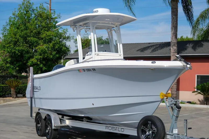 Slide: The Image of 2023 Robalo R230 Center Console boat on trailer, parked outdoors. - 4