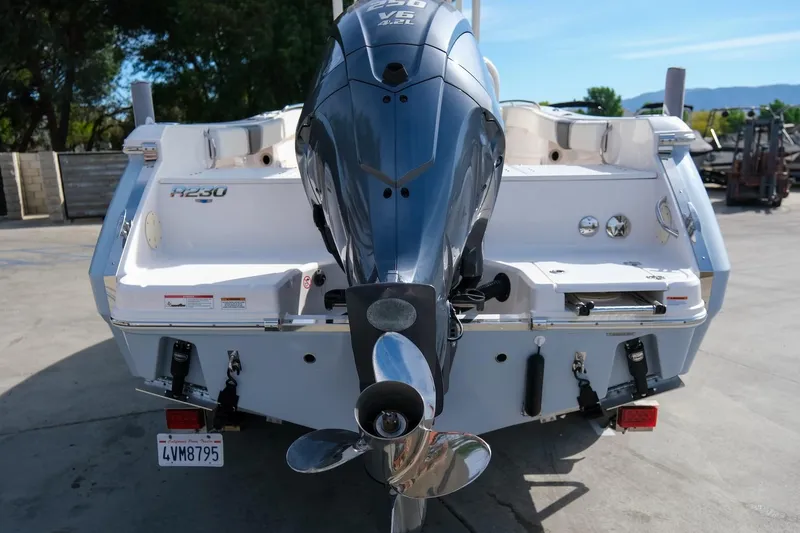 Slide: The Image of 2023 Robalo R230 Center Console boat with powerful outboard motor, parked outdoors. - 7