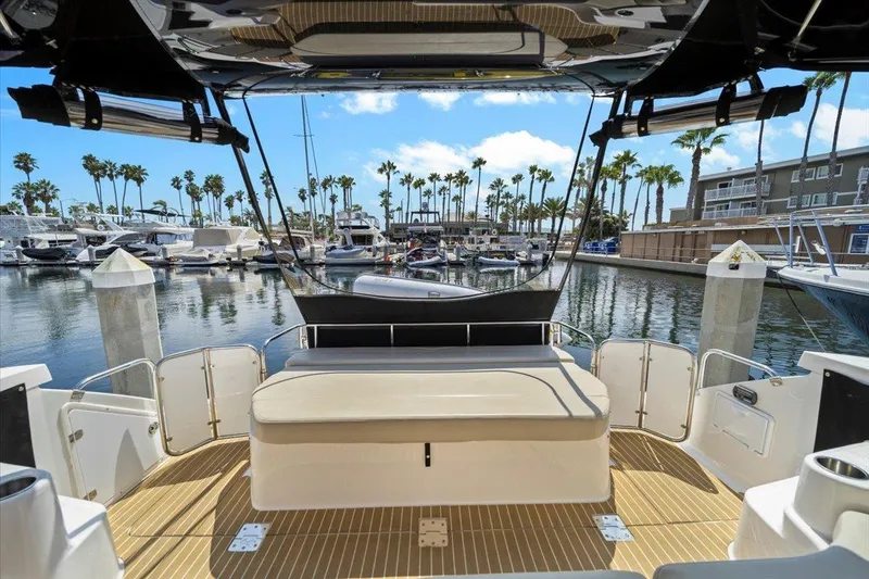 Slide: The Image of 2010 Regal Commodore 4460 yacht interior with marina view, featuring palm trees and docked boats. - 21