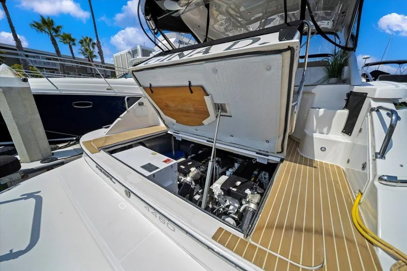 Slide: The Image of 2010 Regal Commodore 4460 yacht with open engine compartment, docked under blue sky. - 36