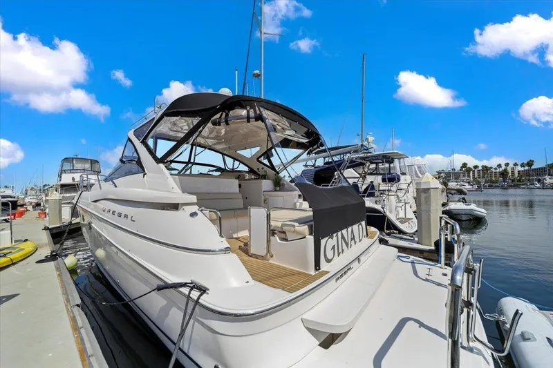 Slide: The Image of 2010 Regal Commodore 4460 yacht docked at marina under clear blue sky. - 7
