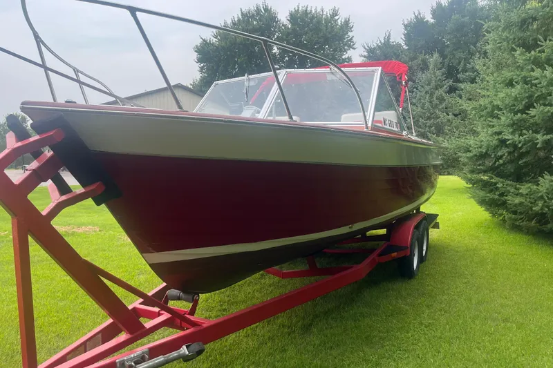 Slide: The Image of 1964 Chris-Craft Sea Skiff boat on trailer, red hull, parked on grass. - 3