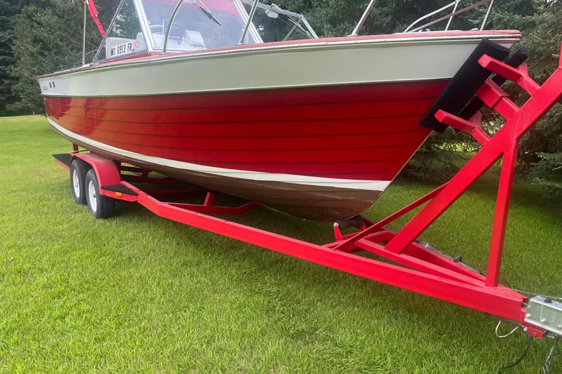 Slide: The Image of 1964 Chris-Craft Sea Skiff on red trailer, parked on green grass. - 2