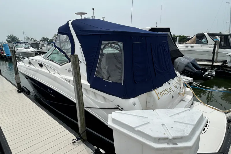 Slide: The Image of 2005 Sea Ray 320 Sundancer docked with blue canopy in marina. - 1