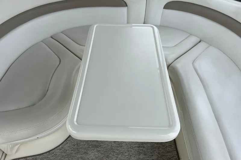 Slide: The Image of Interior seating area of 2005 Sea Ray 320 Sundancer with white cushioned seats and table. - 16