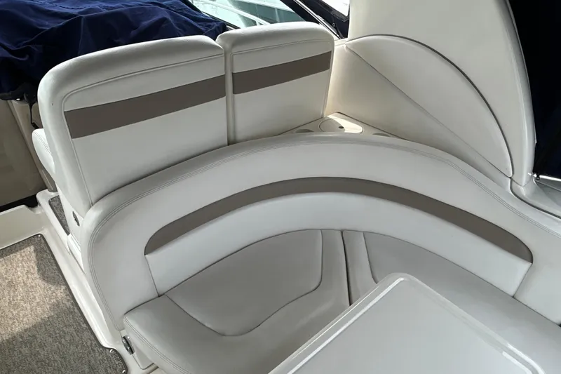 Slide: The Image of Interior seating of a 2005 Sea Ray 320 Sundancer boat, featuring white and beige upholstery. - 17