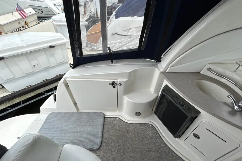 Slide: The Image of 2005 Sea Ray 320 Sundancer boat interior with kitchenette and seating area. - 18