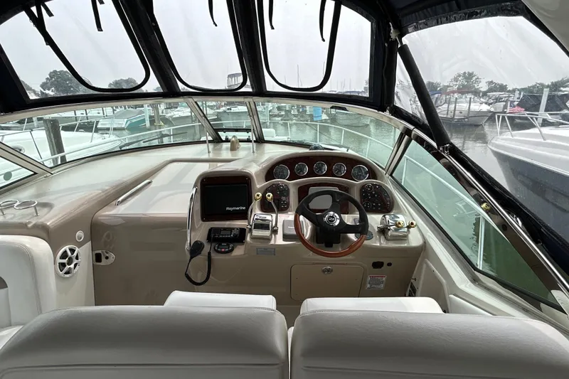 Slide: The Image of 2005 Sea Ray 320 Sundancer helm with modern controls and marina view. - 25