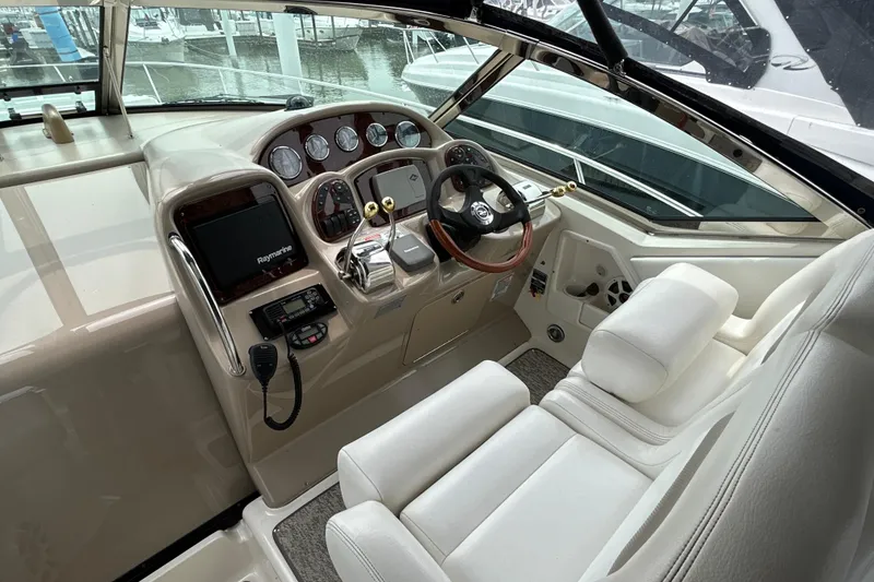 Slide: The Image of 2005 Sea Ray 320 Sundancer helm with steering wheel, gauges, and navigation equipment. - 27