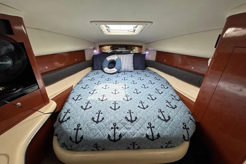 Slide: The Image of Cozy cabin interior of 2005 Sea Ray 320 Sundancer with nautical-themed bedding. - 48
