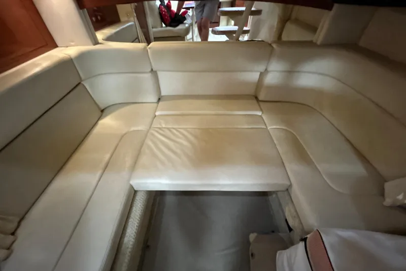Slide: The Image of Interior seating area of a 2005 Sea Ray 320 Sundancer yacht, featuring cream leather upholstery. - 56