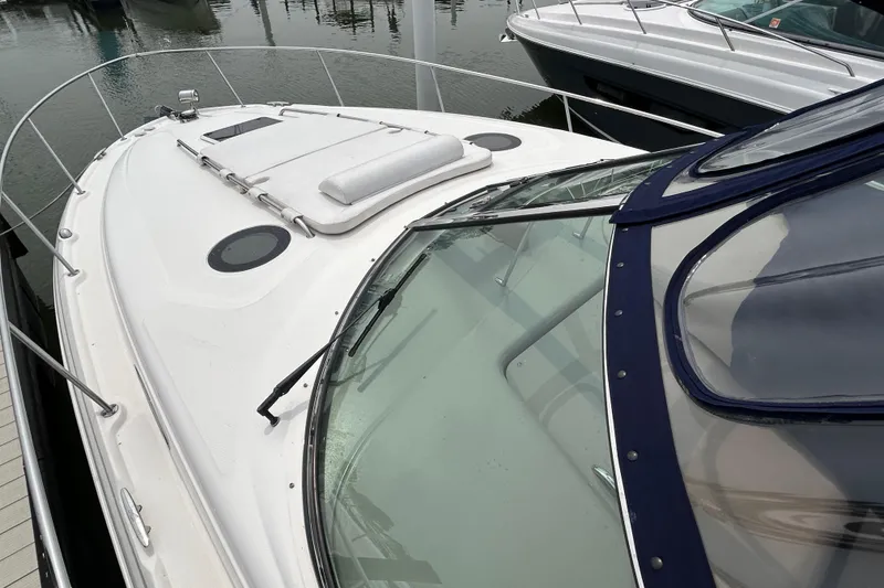 Slide: The Image of 2005 Sea Ray 320 Sundancer boat docked, featuring sleek design and spacious deck. - 6