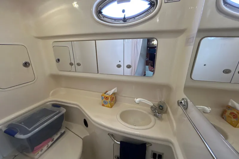 Slide: The Image of 2005 Sea Ray 320 Sundancer bathroom with sink, mirror, and storage compartments. - 60