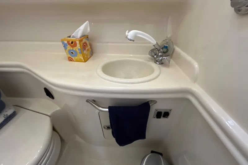 Slide: The Image of Bathroom sink area in 2005 Sea Ray 320 Sundancer yacht, featuring faucet and tissue box. - 61