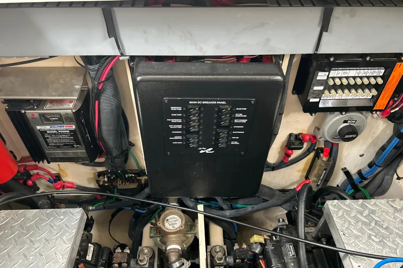 Slide: The Image of Engine compartment of a 2005 Sea Ray 320 Sundancer, featuring electrical panels and wiring. - 69