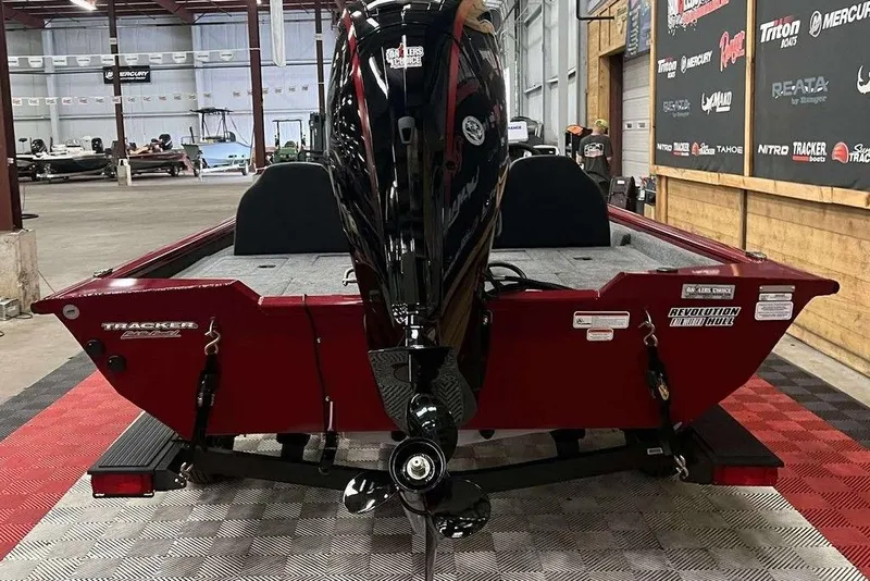 Slide: The Image of 2026 Tracker Pro Team™ 190 boat in showroom, rear view with motor, red hull. - 4