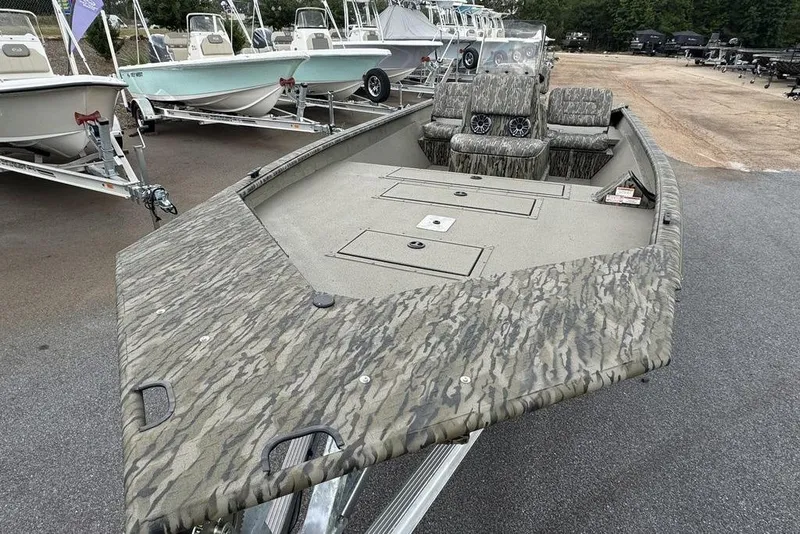 Slide: The Image of 2026 SeaArk Shadow 20 Elite CC boat with camouflage design, parked on a trailer. - 14