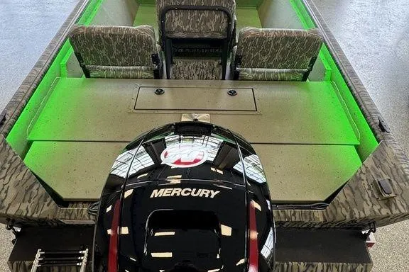 Slide: The Image of 2026 SeaArk Shadow 20 Elite CC boat with Mercury engine and green interior lighting. - 7