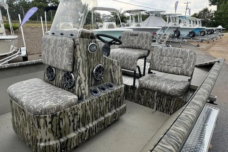 Slide: The Image of 2026 SeaArk Shadow 20 Elite CC boat with camouflage seating and console, displayed outdoors. - 9