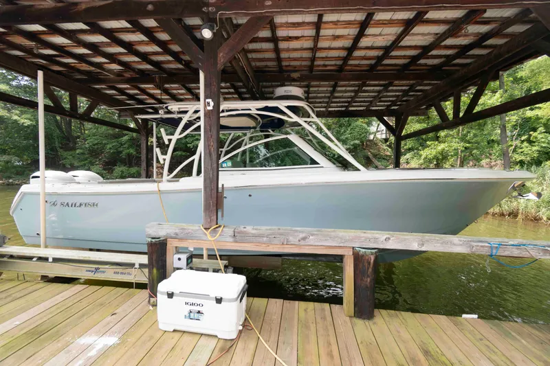 The Image of 2020 Sailfish 325 DC boat docked under wooden shelter, side view. - 0