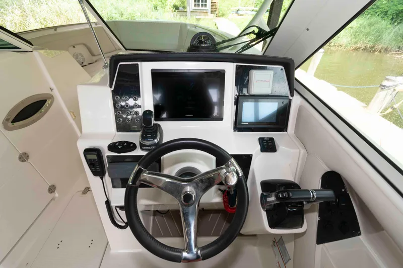 Slide: The Image of 2020 Sailfish 325 DC boat cockpit with steering wheel and navigation controls. - 11