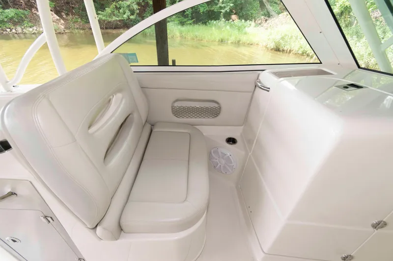 Slide: The Image of 2020 Sailfish 325 DC interior seating area with white upholstery and window view. - 15