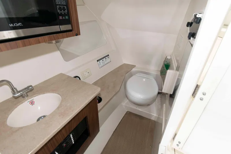 Slide: The Image of 2020 Sailfish 325 DC boat interior with sink, toilet, and microwave. - 23