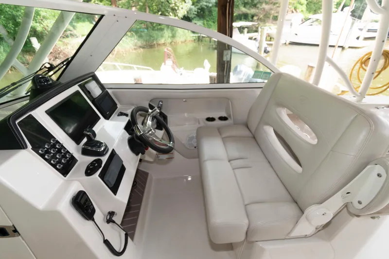 Slide: The Image of 2020 Sailfish 325 DC boat interior with steering wheel and seating area. - 6