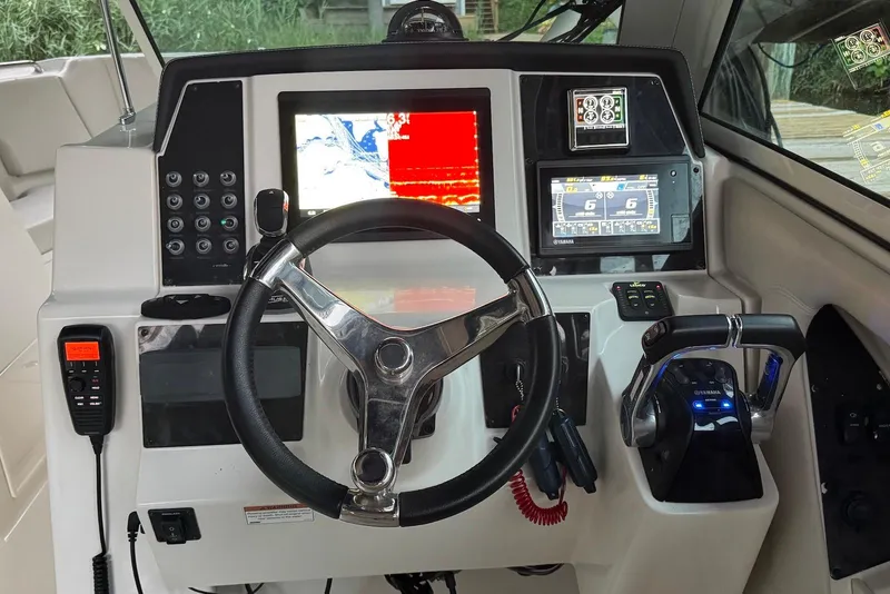 Slide: The Image of 2020 Sailfish 325 DC boat dashboard with steering wheel, navigation screens, and controls. - 8