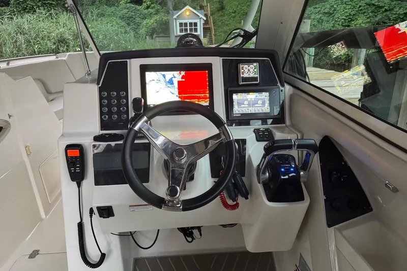 Slide: The Image of 2020 Sailfish 325 DC boat cockpit with steering wheel and navigation controls. - 9