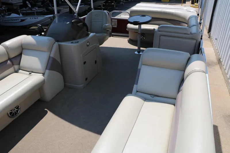 Slide: The Image of 2014 Veranda Relax V2275 pontoon boat interior with beige seating and helm. - 12
