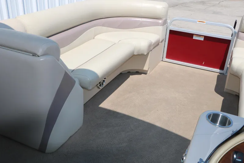 Slide: The Image of 2014 Veranda Relax V2275 pontoon boat interior with beige seating and red gate. - 25
