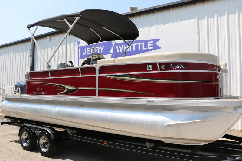 Slide: The Image of 2014 Veranda Relax V2275 pontoon boat with red exterior and black canopy on trailer. - 3