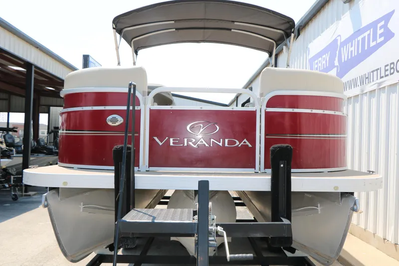 Slide: The Image of 2014 Veranda Relax V2275 pontoon boat with red exterior, displayed at a dealership. - 5