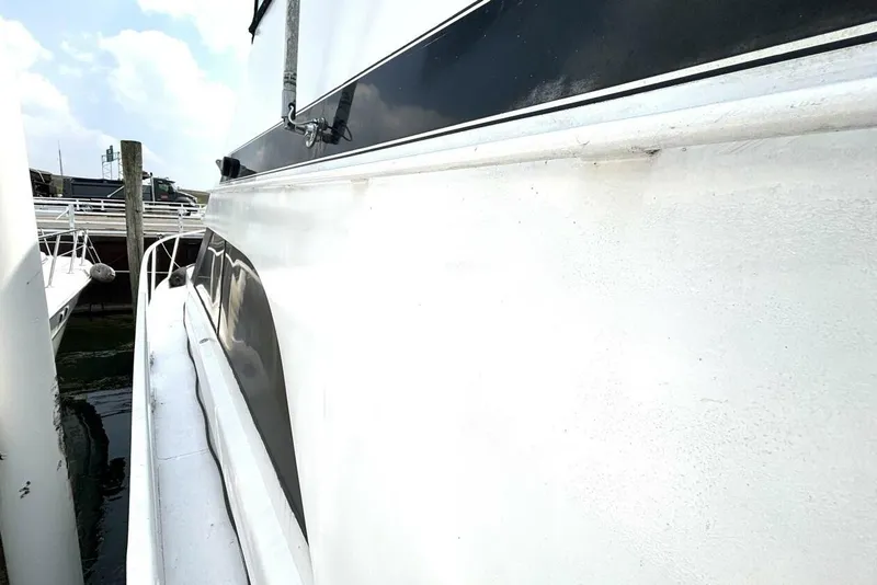 Slide: The Image of 1987 Davidson 48 Sportfish boat docked, showcasing sleek white exterior and black accents. - 10