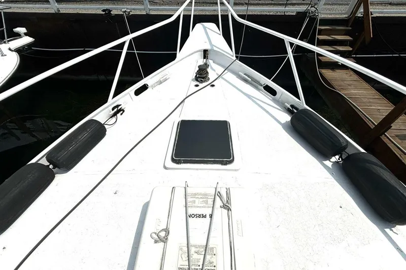 Slide: The Image of 1987 Davidson 48 Sportfish boat deck with fenders and hatch, docked at marina. - 11