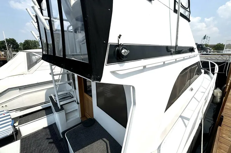 Slide: The Image of 1987 Davidson 48 Sportfish yacht docked, featuring sleek design and spacious deck area. - 13