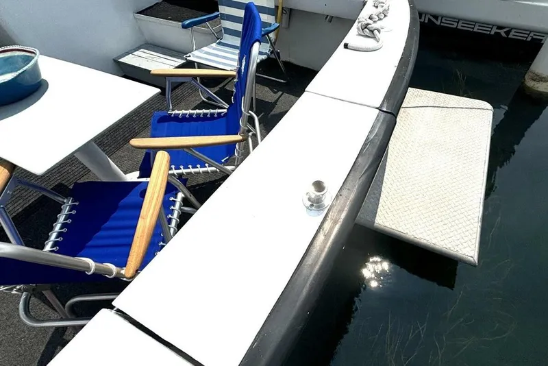 Slide: The Image of 1987 Davidson 48 Sportfish deck with blue chairs and table by the water. - 18