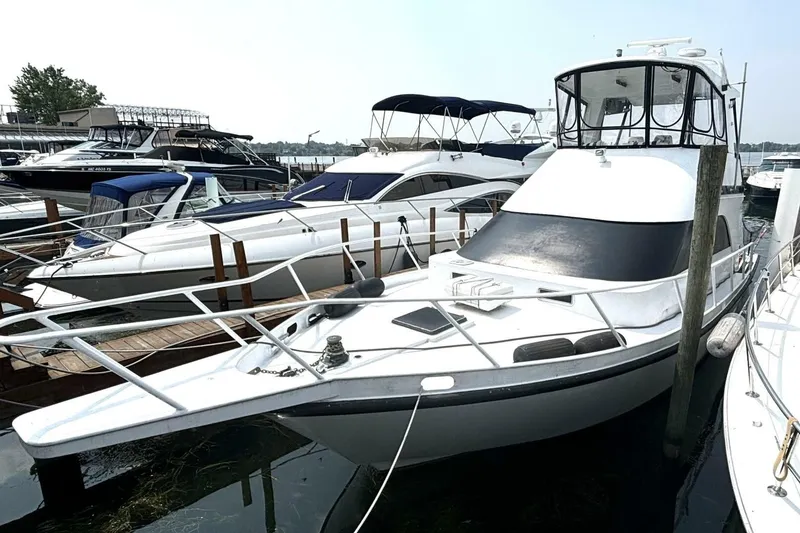 Slide: The Image of 1987 Davidson 48 Sportfish yacht docked among other boats at a marina. - 2