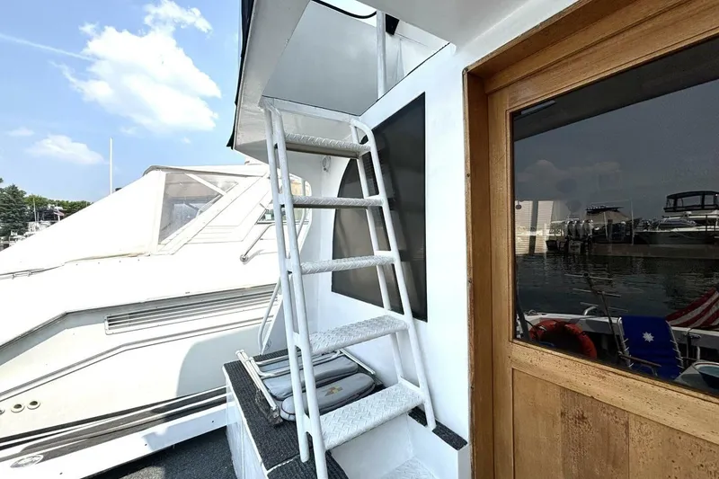 Slide: The Image of 1987 Davidson 48 Sportfish yacht with exterior ladder and wooden door, docked at marina. - 20