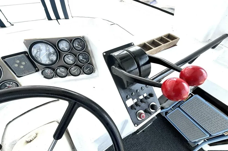Slide: The Image of Control panel of a 1987 Davidson 48 Sportfish boat with gauges and throttle levers. - 26