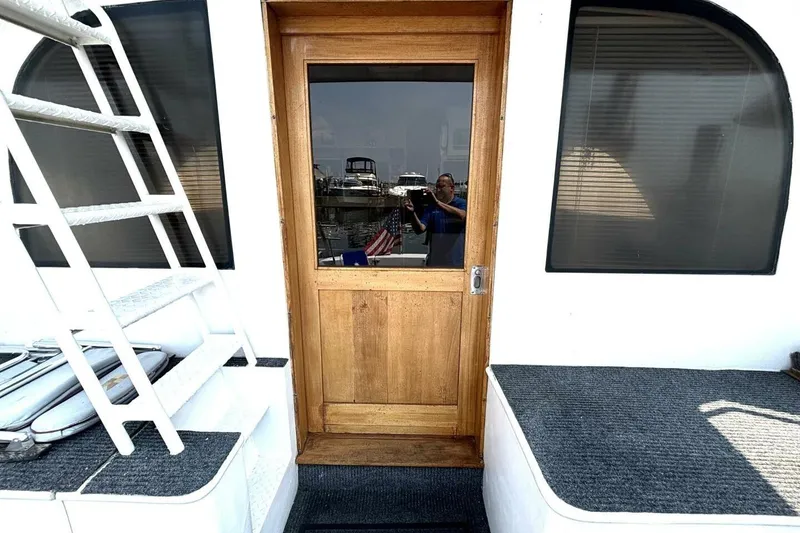 Slide: The Image of 1987 Davidson 48 Sportfish boat with wooden door and exterior seating area. - 32