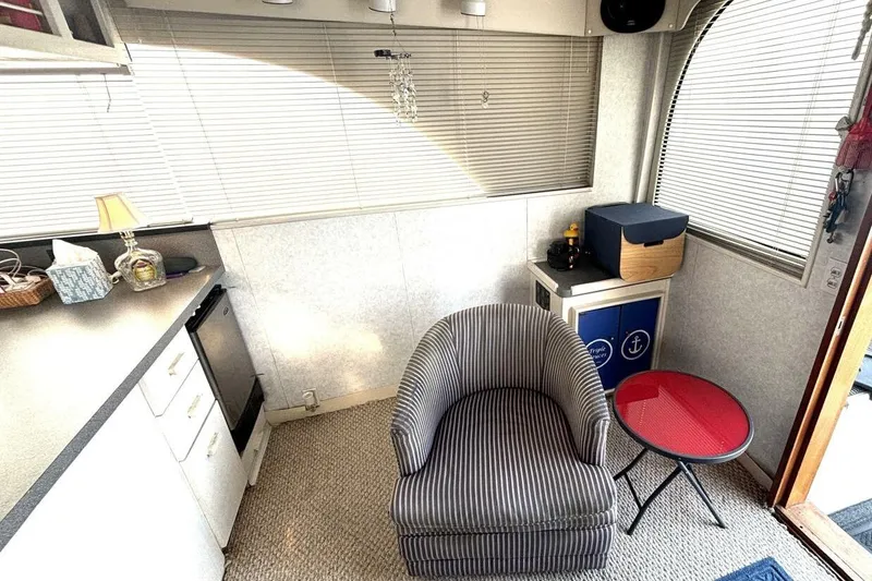 Slide: The Image of 1987 Davidson 48 Sportfish interior with striped chair, compact kitchen, and red table. - 35