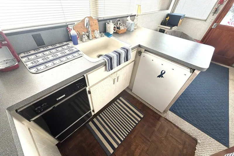 Slide: The Image of 1987 Davidson 48 Sportfish kitchen with nautical decor, featuring sink, countertop, and appliances. - 38
