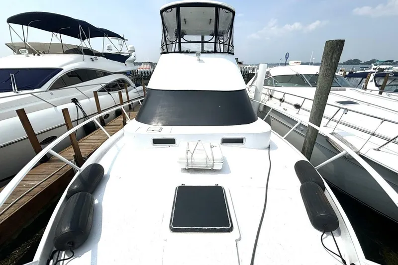 Slide: The Image of 1987 Davidson 48 Sportfish yacht docked among other boats at a marina. - 4