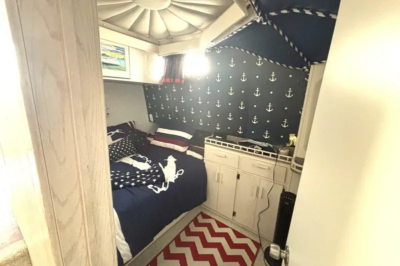 Slide: The Image of Nautical-themed bedroom in 1987 Davidson 48 Sportfish boat with anchor wallpaper and cozy bedding. - 41