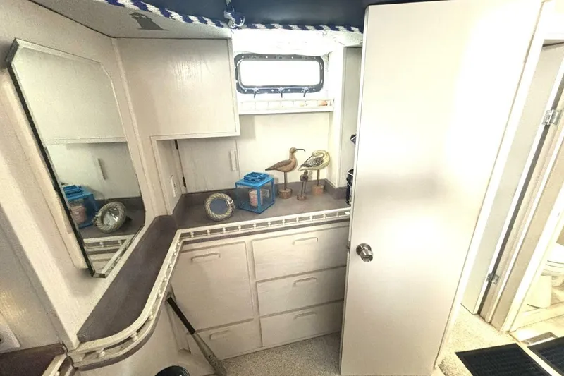 Slide: The Image of 1987 Davidson 48 Sportfish interior with cabinets, mirror, and nautical decor. - 43